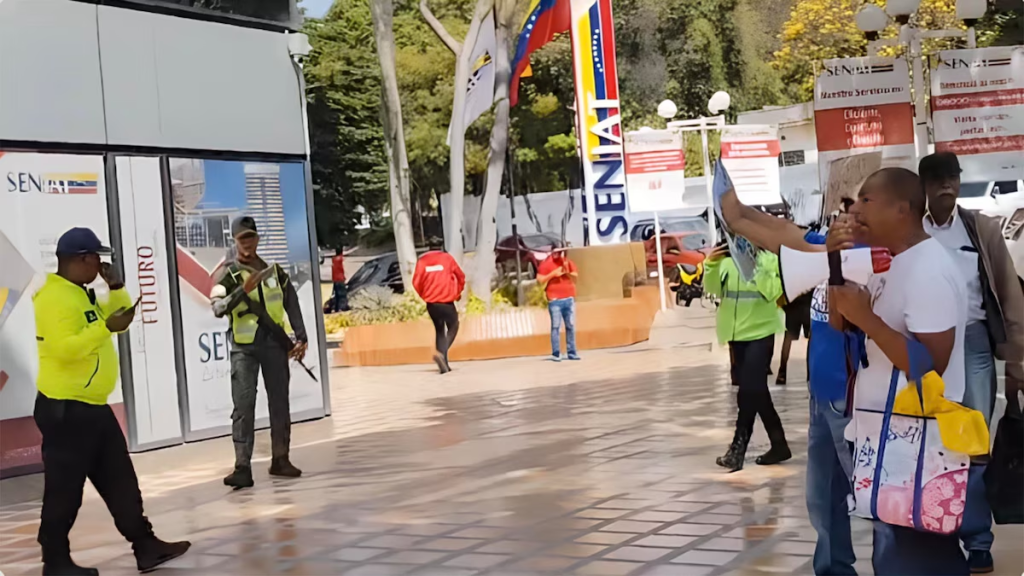 Funcionarios militares y policiales grabando a los manifestantes frente al SENIAT mientras José Salazar exige reivindicaciones laborales